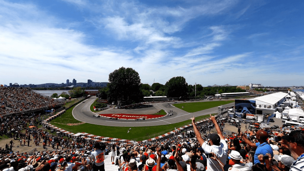 Cheering crowd as F1 cars race through the turn