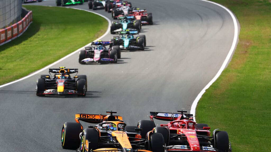 F1 cars taking a corner on a track.