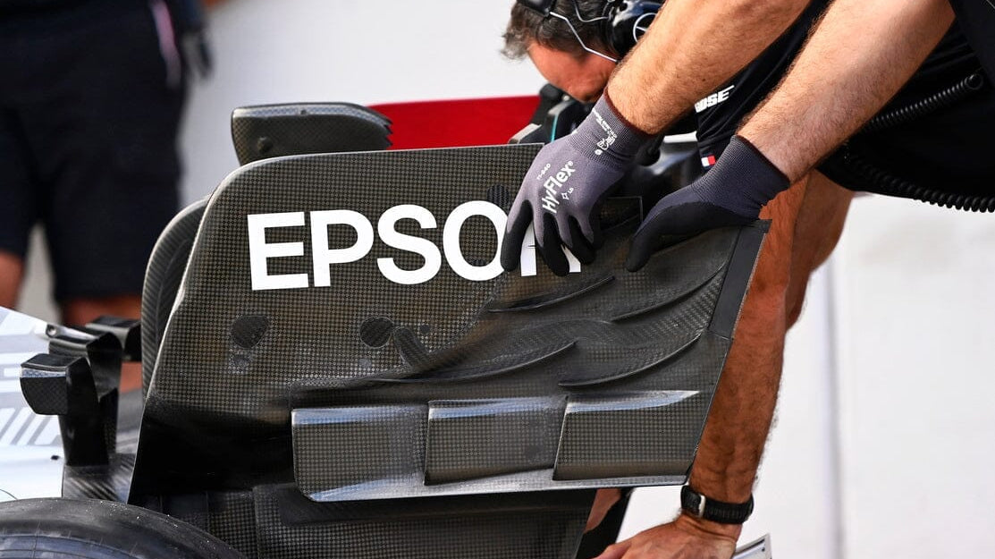 Man with gloves making 2022 f1 car changes to rear wing