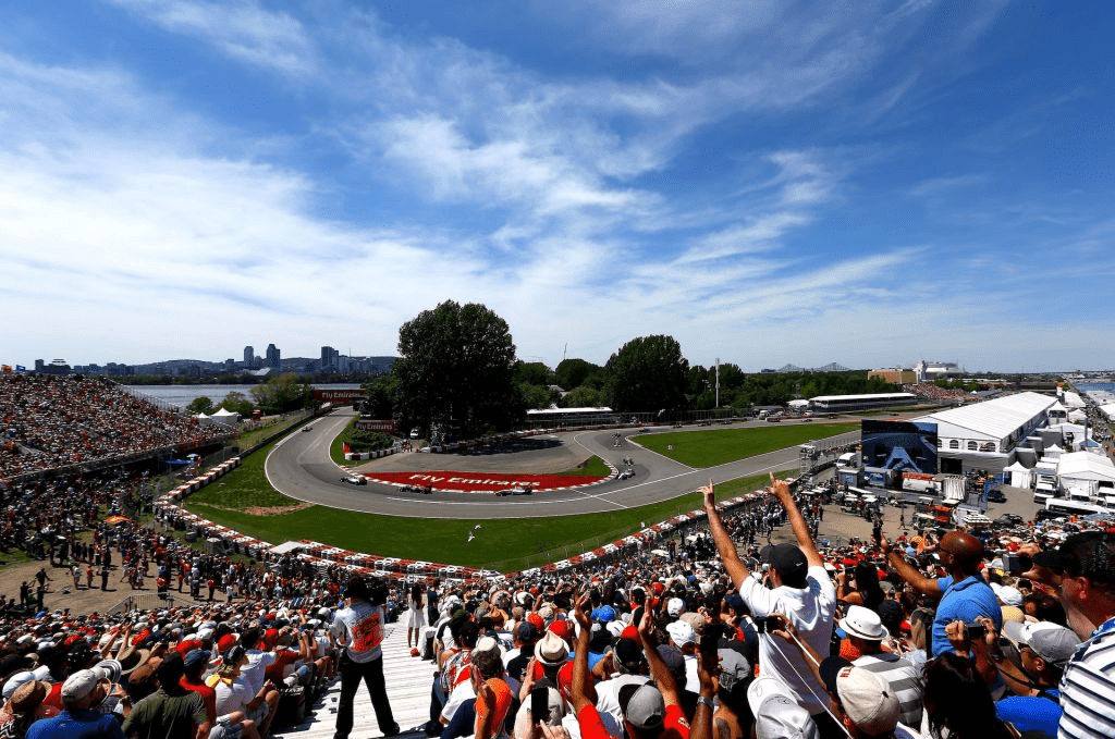 Cheering crowd as F1 cars race through the turn