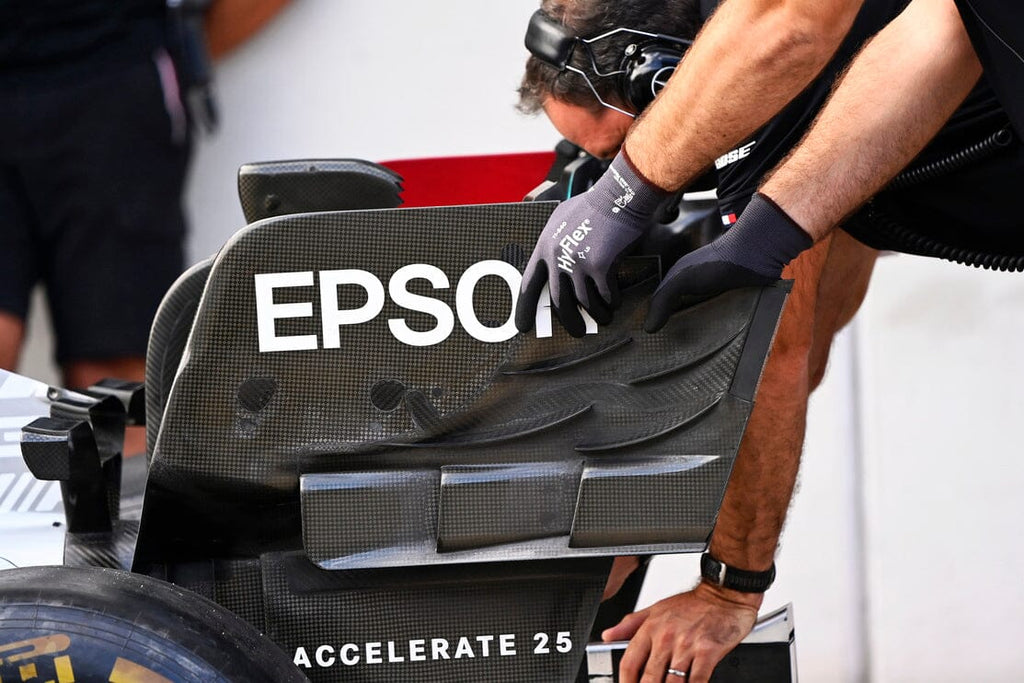 Man with gloves making 2022 f1 car changes to rear wing