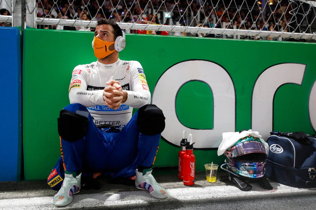 Race car driver with mask squatting on a bench